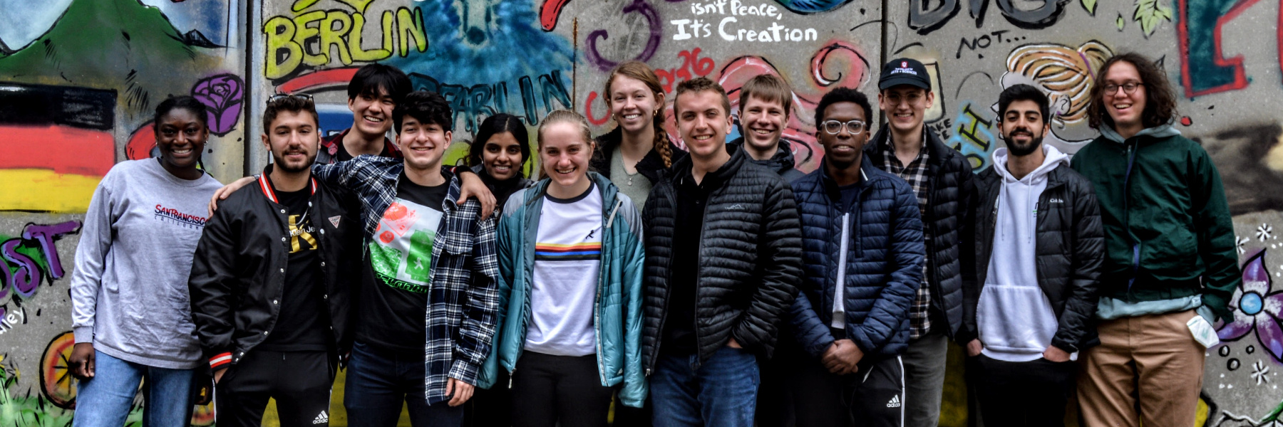 An image of Wells Scholars students standing in front of a wall with graffiti in Berlin. 